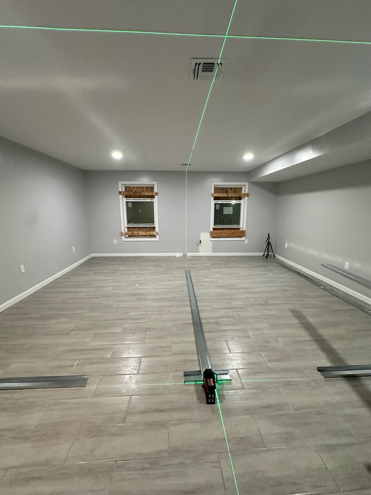 Finished basement room laid out with laser lines during ARCED interior work