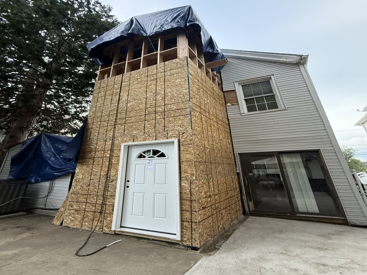 Real ARCED addition — new walkout basement entrance, framed and sheathed onto the existing house