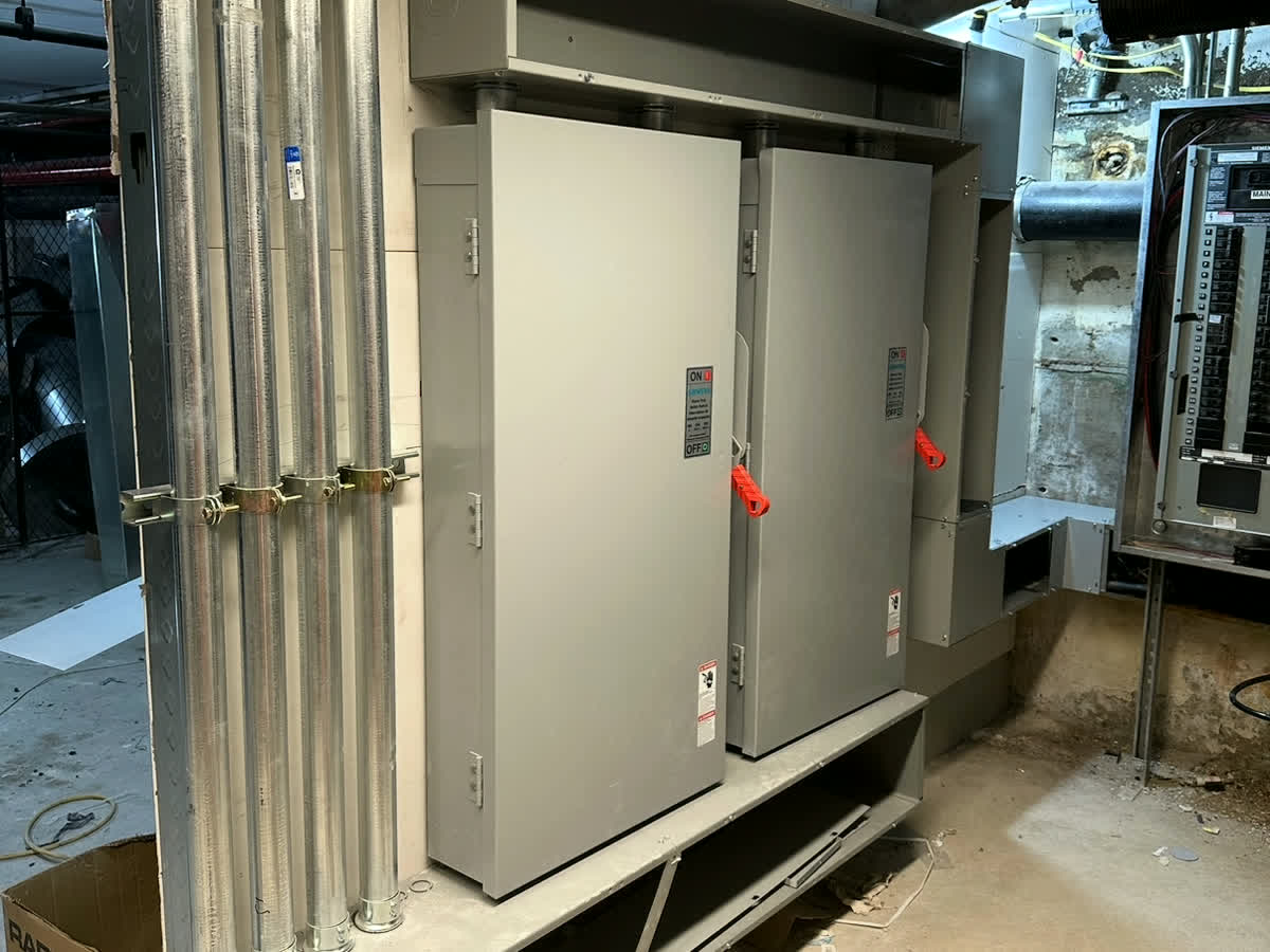 Real ARCED electrical — twin service disconnects with conduit runs, tied into the main panel